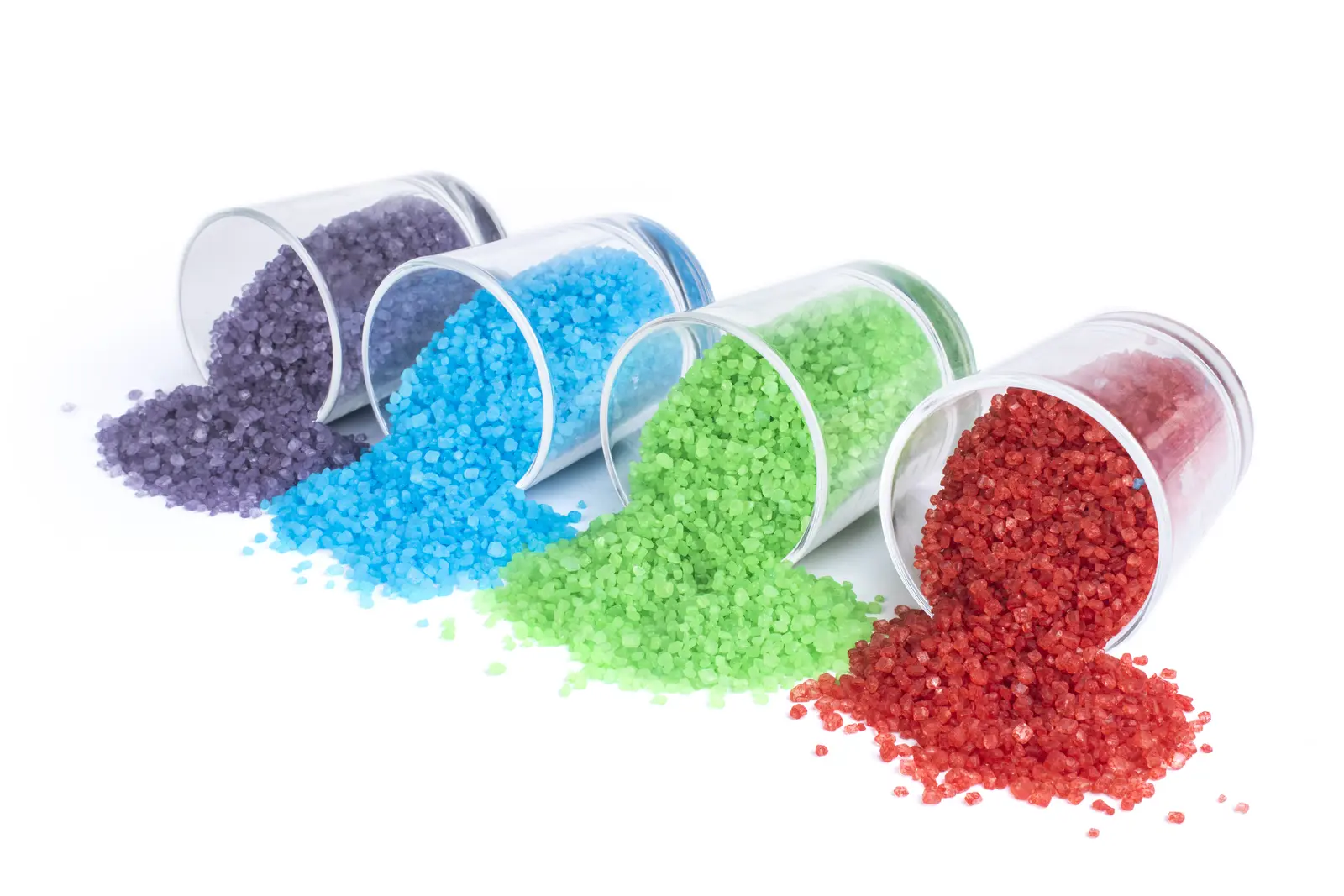 Purple, blue, green and red coloured sugar spilling from transparent containers