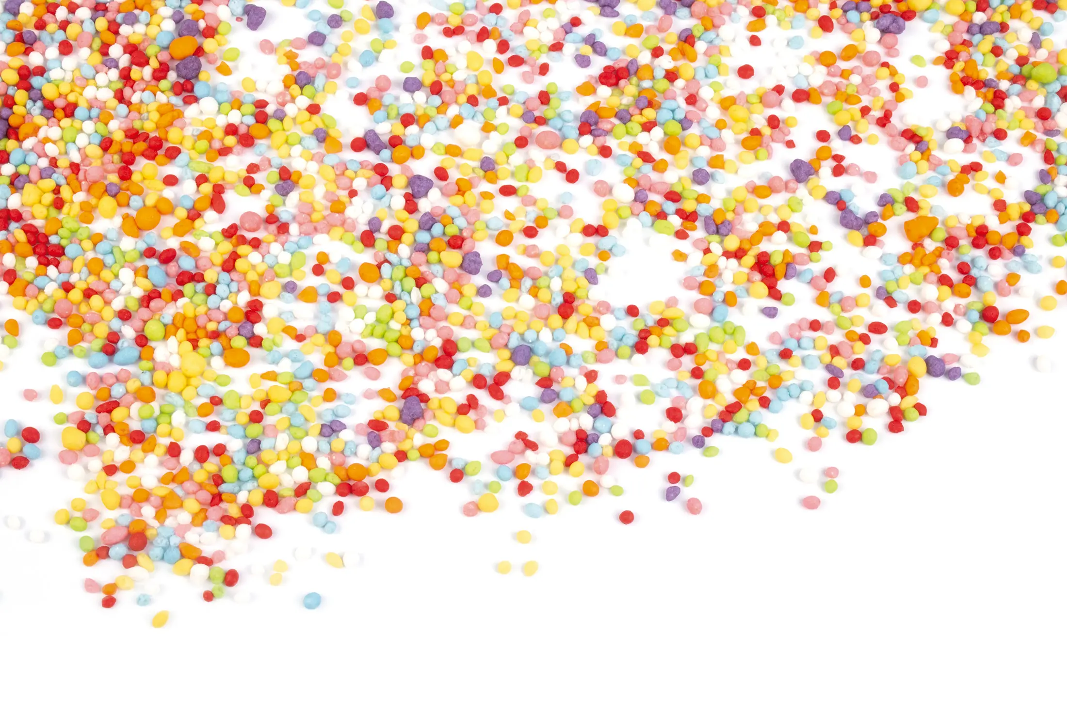 Colourful Crunchy Pearls scattered across a white background