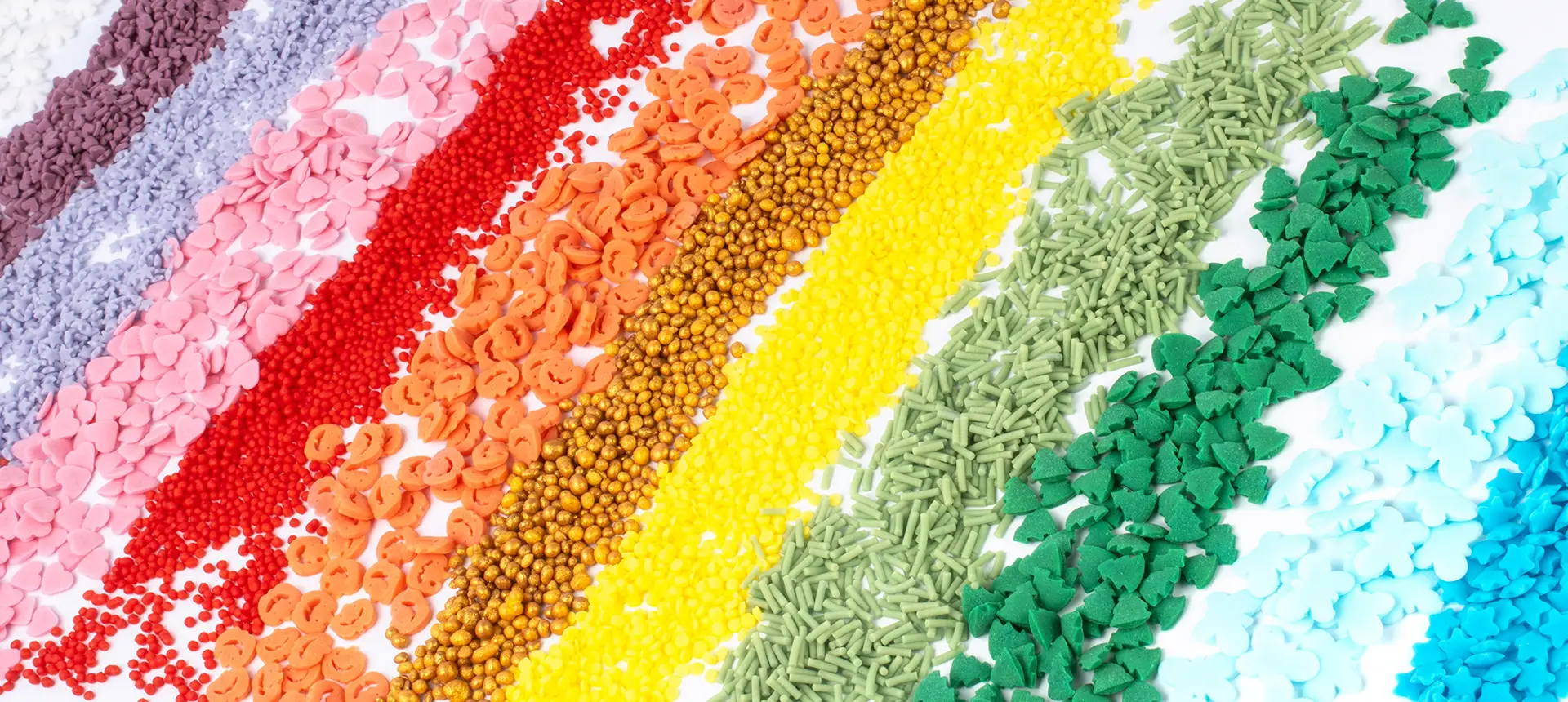 A rainbow composition of sprinkles and sugar decorations