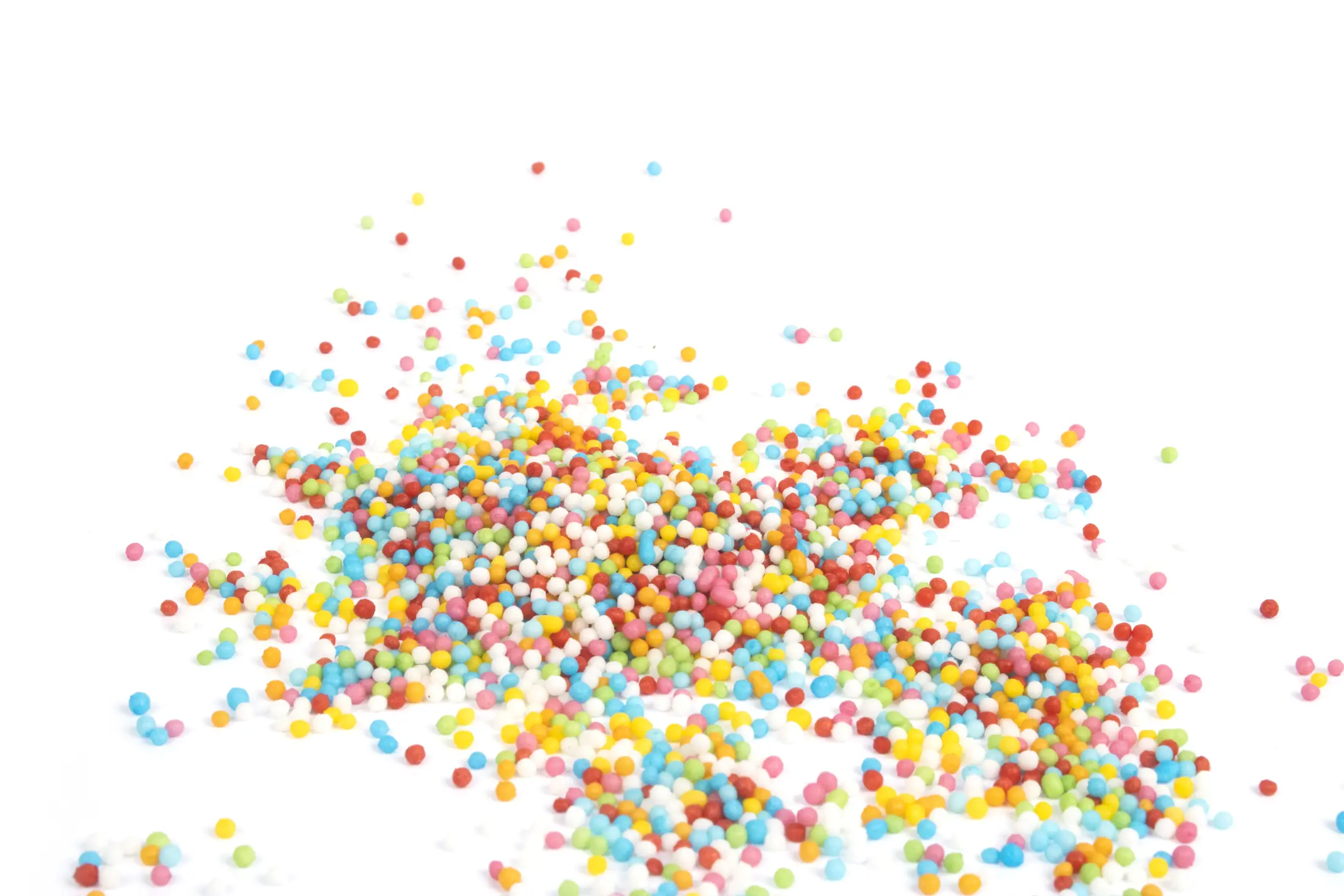Colourful nonpareils scattered across a white background